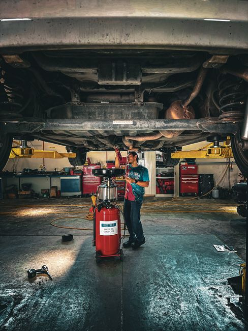 Szerelő az emelőn álló autó alatt dolgozik az Autonex műhelyében